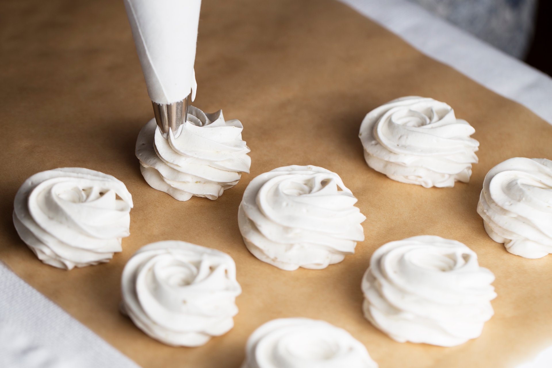 close-up-hands-chef-with-confectionery-bag-cream-parchment-paper-pastry-shop-kitchen